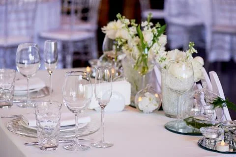 Classic table setting. White tablecloth. Vase with hydrogel and white flowers Stock Photos