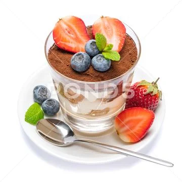 Classic tiramisu dessert with blueberries and strawberries in a glass isolated Stock Photos