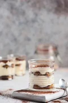 Classic tiramisu in a glass on a gray background. Poster copy space concept. Stock Photos