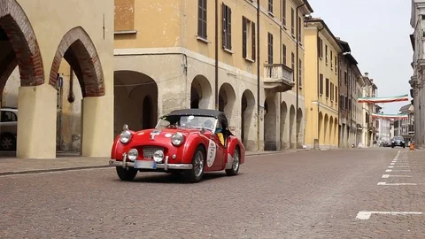 Classic triumph red car in typical Italian city Stock Footage 90135146