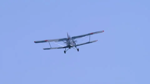 Classic Utility Plane Antonov AN-2 Flying Away Into Blue Sky Tracking Shot Stock Footage 332324961