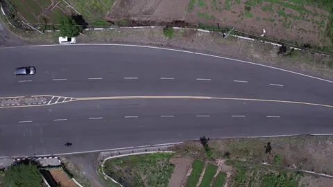 A classic van cruises down a quiet, tree-lined road. Stockbeeldmateriaal 310548877