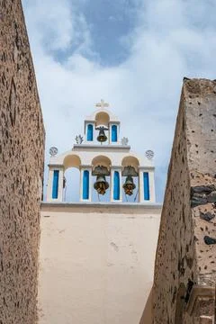 Classic view of three bells on a white church tower in Santorini. Stock Photos