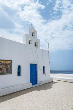 Classic view of three bells on a white church tower in Santorini. Stock Photos