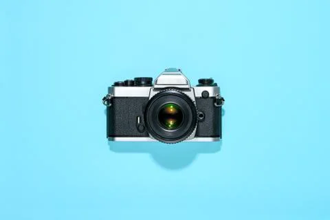 Classic vintage reflex camera centered on blue Stock Photos