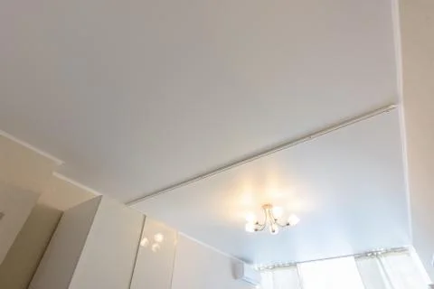 Classic white matte stretch ceiling with separation for curtains in two halve Stock Photos