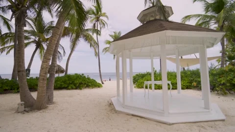 Classic white wedding altar next to a paradisiacal beach with palm trees Stock Footage 257430440