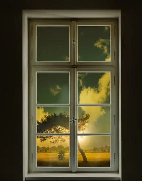 Classic white window and view of a tree outside with sunset Stock Photos