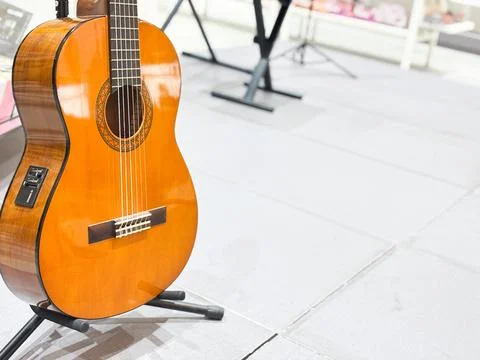 Classical Acoustic-Electric Nylon String Guitar on Stand in Music Store Stock Photos