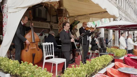 Classical band of musicians playing instruments at outdoor cafe in Venice Italy Stock Footage 325315823