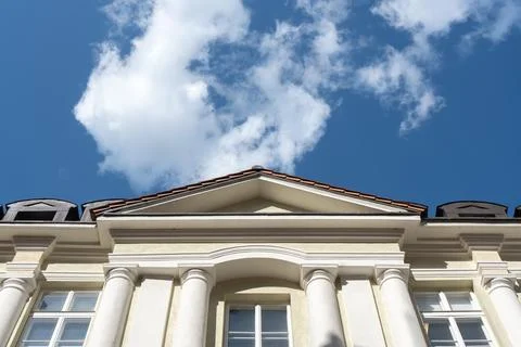 Classical building facade with columns and triangular pediment under sky Stock Photos