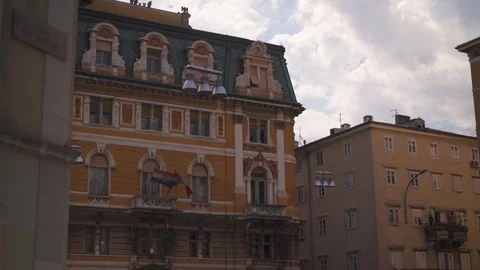 Classical building with yellow facade in Rijeka, Croatia, flags of Vídeos de archivo 111162940