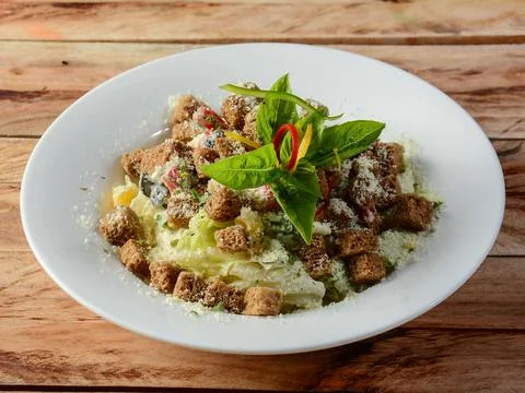 Classical Caesar salad, isolated over a rustic wooden background, selective f Stock Photos