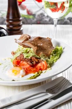 Classical Caesar salad with roasted chicken, poached egg, lettuce leaves Stock Photos