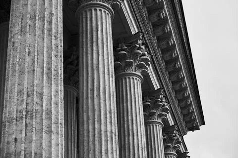 Classical corinthian colonnade captured in dramatic low-angle black and white Foto stock