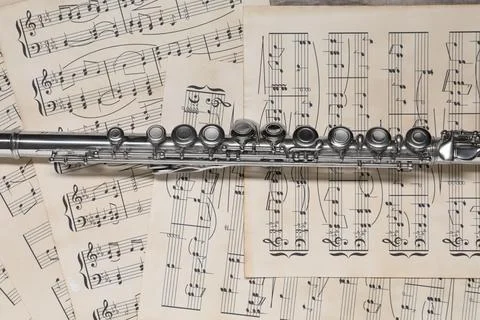 Classical flute on sheets with musical notes, top view Photos