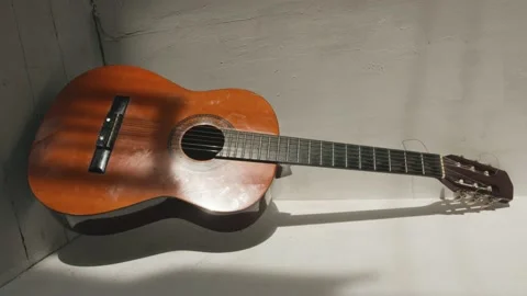 A classical guitar stands in the corner of the room against the backdrop of Stock-Footage 156962740