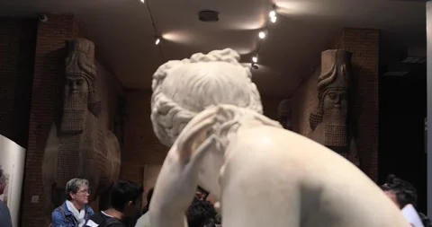 Classical marble statue in British Museum with Assyrian relief behind Stock Footage 321020261