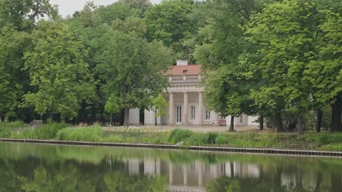 Classical pavilion with columns reflected in the pond in Lazienki Park in Warsaw Vídeos de archivo 331459277
