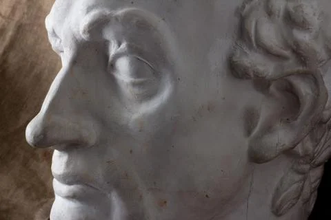 Classical plaster head bust against a background of rough brown fabric, Stock Photos