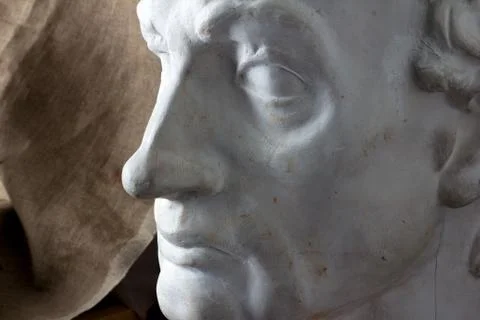 Classical plaster head bust against a background of rough brown fabric, Stock Photos