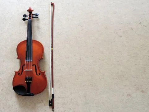 Classical red violin with bow on gray background. Classical musical instrumen 스톡 사진