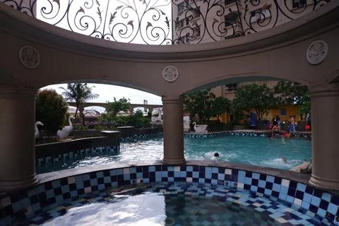 Classical Rotunda with Decorative Ironwork Looking Out Over Residential Pool in Stock Photos