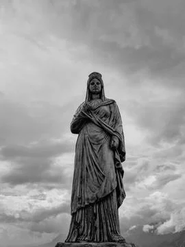 Classical statue under dark dramatic clouds Stock Photos