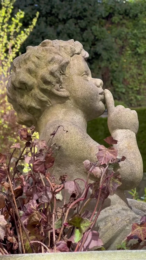 Classical Stone Cherub Statue with Finger on Lips in Garden Видео 346097238