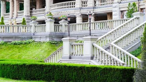 Classical stone staircase leads into lush green park environment Stock Photos