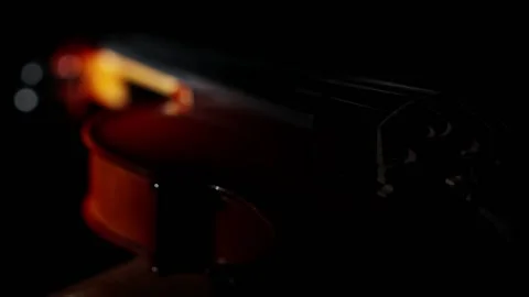 Classical string musical instrument the violin lies in the darkness and is Stock Footage 169579386