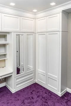 Classical style corner wardrobe on a bright purple carpet Stock Photos