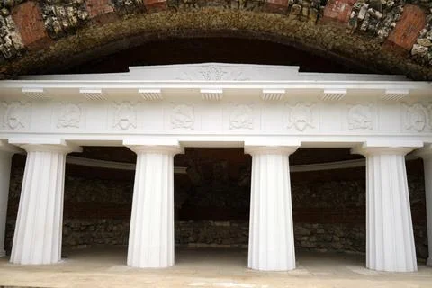 Classical white colonnade built into an ancient stone and brick arch, showc.. 库存照片