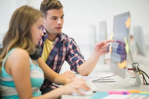 Classmates doing assignment together in the computer room Stock Photos
