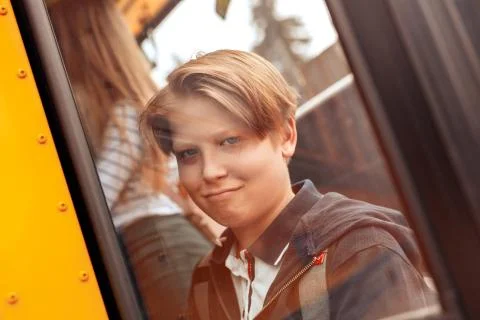 Classmates going to school by bus boy behind window close-up grimace joyful Foto stock