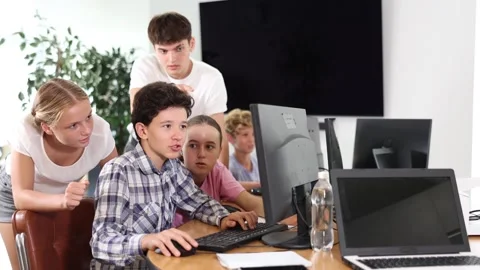 Classmates solve computer problem together in a school computer class Stockbeeldmateriaal 256034264