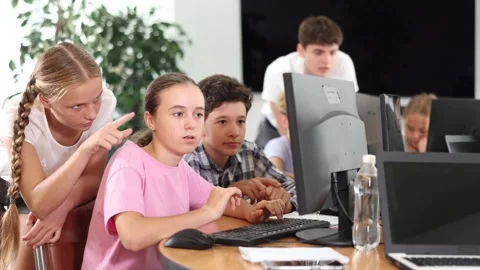 Classmates solve computer problem together in a school computer class Stockbeeldmateriaal 304708806