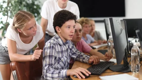 Classmates solve computer problem together in a school computer class Stockbeeldmateriaal 316579900