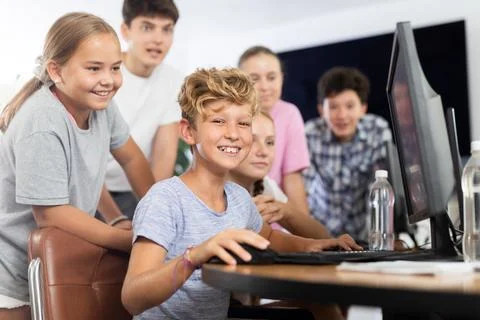 Classmates solve computer problem together in school computer class Stock Photos