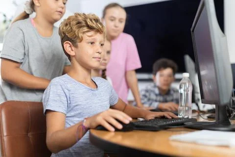 Classmates solve computer problem together in school computer class Stockfoto's
