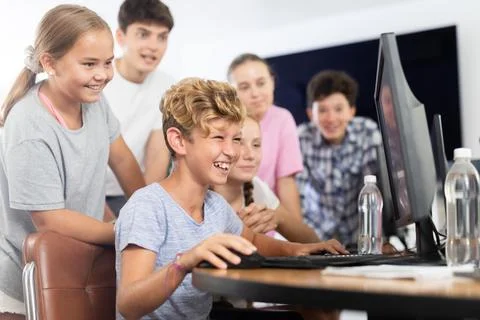 Classmates solve computer problem together in school computer class Stock Photos