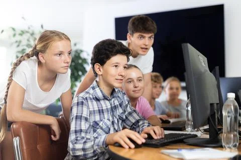 Classmates solve computer problem together in school computer class Stock Photos