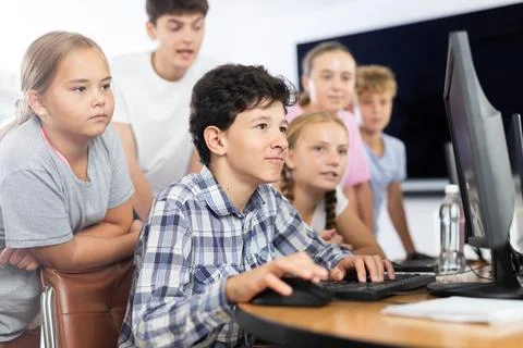 Classmates solve computer problem together in school computer class Stock Photos