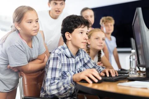 Classmates solve computer problem together in school computer class Stock Photos