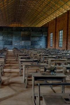 Classroom containing old school desks with old sewing machines. Stock Photos