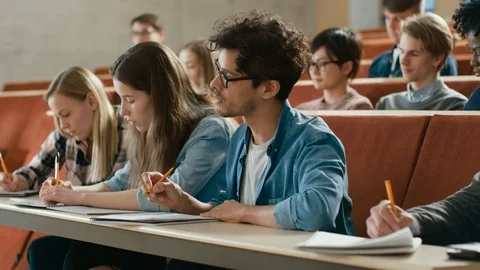 In the Classroom Multi Ethnic Students Listening to a Lecturer and Write. Stock Footage 87974288