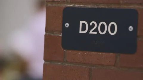 Classroom number D200 on a brick wall in an educational setting Stock Footage 310212504
