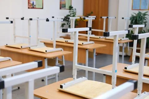 Classroom with raised chairs and empty desks, showcasing a tidy educational Stock Photos
