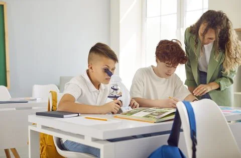 Classroom school study, pupil working with microscope discover world of science Stock Photos