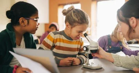 Classroom, teacher and children with microscope for learning, stem education or Fotos de archivo